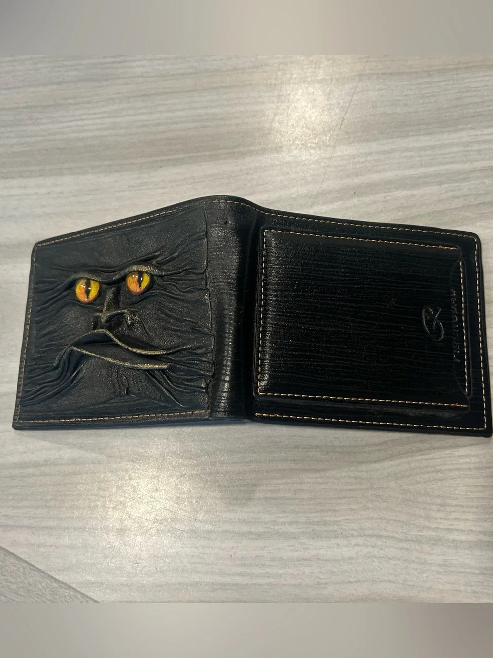 Men's Black Leather Bi-Fold Wallet with Embossed Face and Yellow Eye Accent